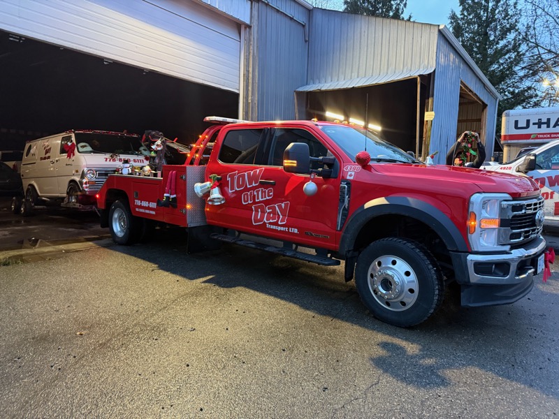 Tow Of The Day red tow truck with company branding